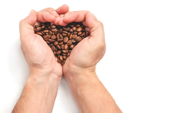 Мужские руки держат кофейные зерна формируя форму сердца на белом фоне . — стоковое фото