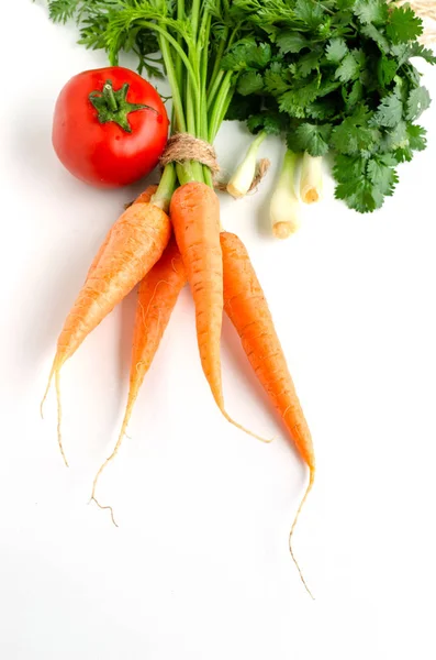 Fresh carrot with green leaves, tomato, onion and parsley on white background. — Stock Photo, Image