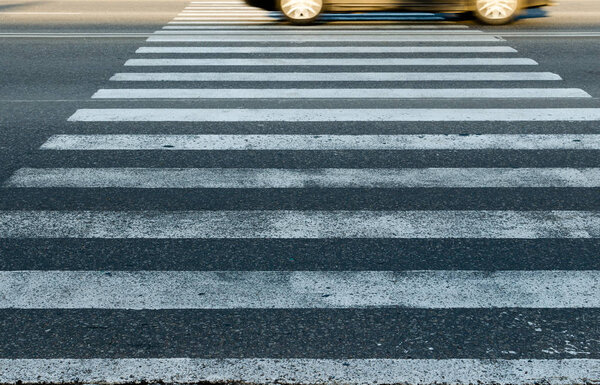 Car at high speed passes through a pedestrian Zebra.