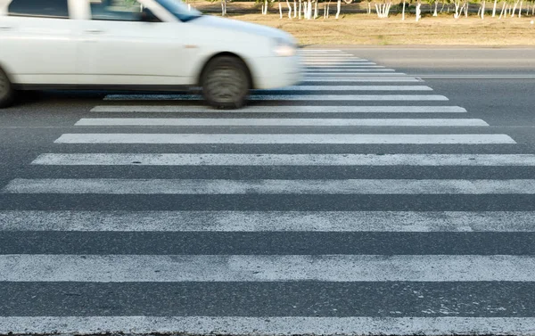 Car at high speed passes through a pedestrian Zebra. — Stock Photo, Image