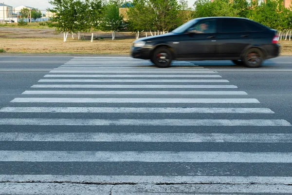 Car at high speed passes through a pedestrian Zebra. — Stock Photo, Image