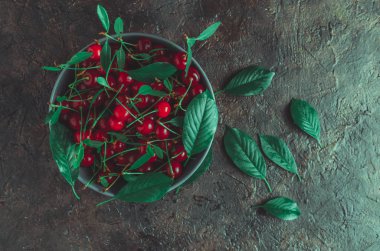 Eski bir masada mavi kase kiraz.