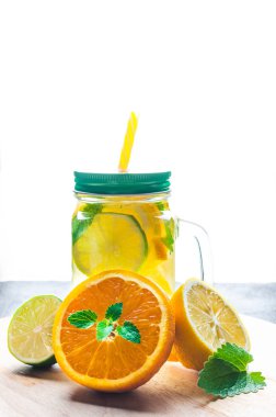 Kontur güneş ışığının arka planında portakal, limon, limon ve nane limonata.