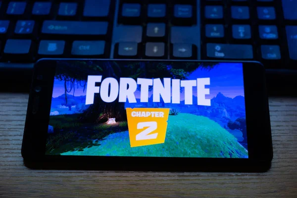 Kostanay, Kazajstán, 15 de octubre de 2019.Teléfono móvil en el fondo del teclado, con el logotipo del popular juego fortnite 2, de Epic Games . —  Fotos de Stock