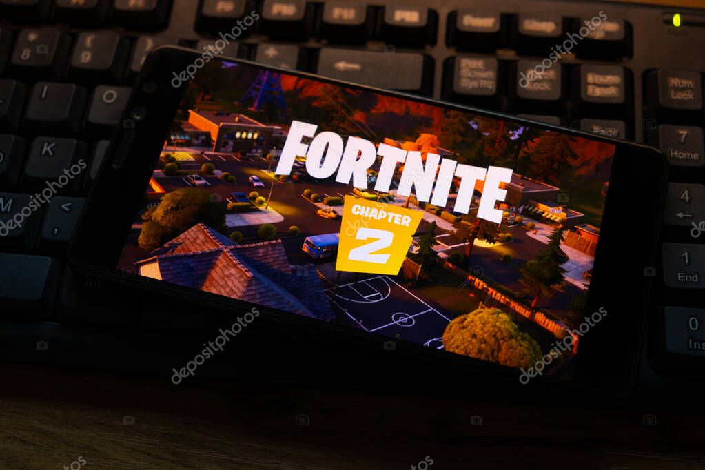 Kostanay, Kazakhstan, October 15, 2019.Mobile phone on the background of the keyboard, with the logo of the popular game fortnite 2, from Epic Games.