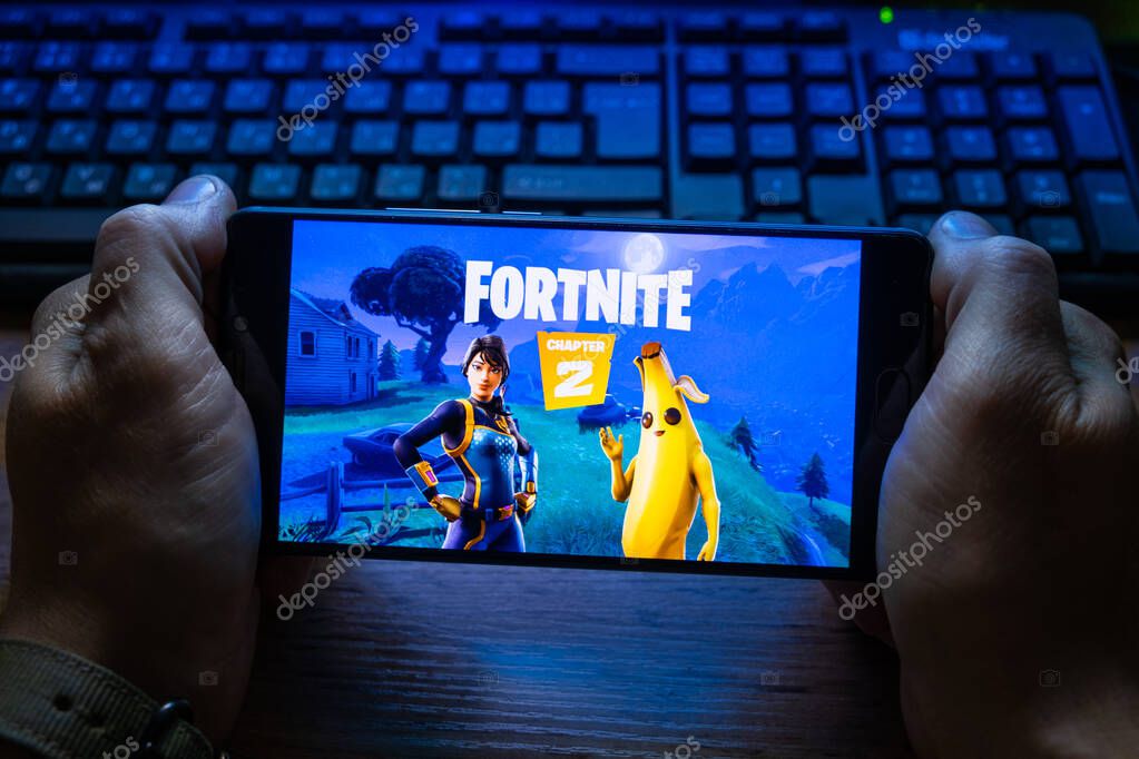 Kostanay, Kazakhstan, October 15, 2019.A man holds a mobile phone with a screensaver of the popular game Fortnite 2, from Epic Games.