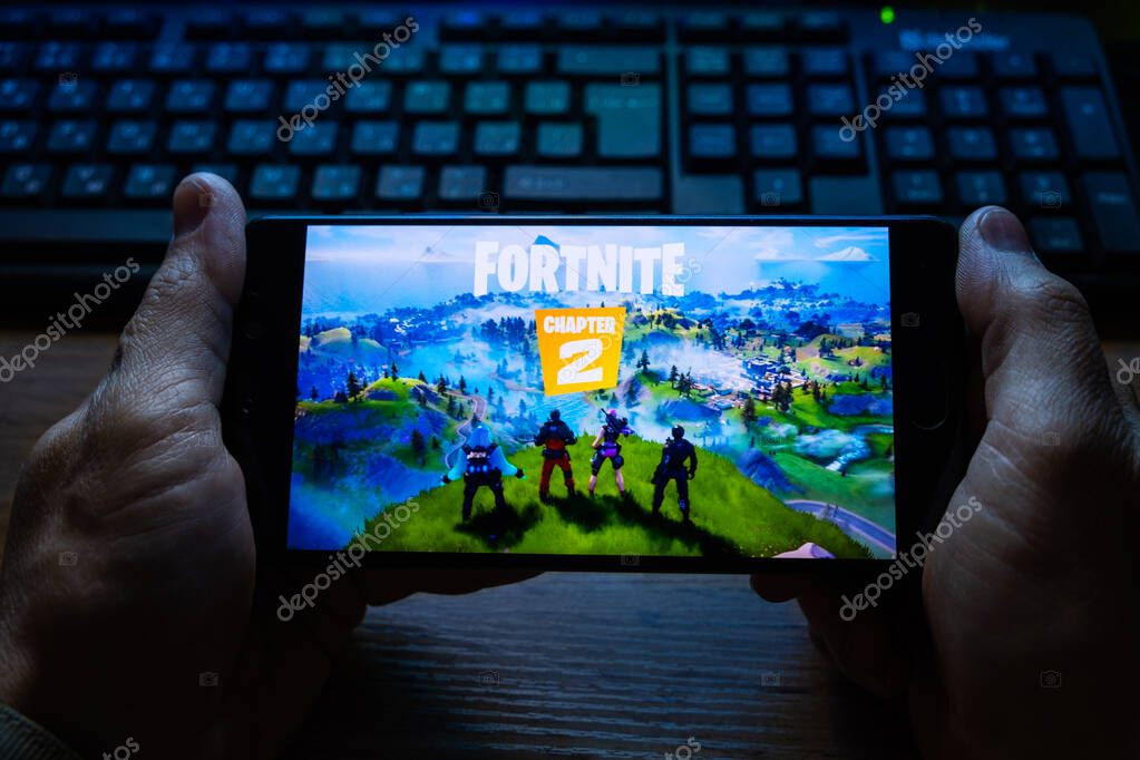 Kostanay, Kazakhstan, October 15, 2019.A man holds a mobile phone with a screensaver of the popular game Fortnite 2, from Epic Games.