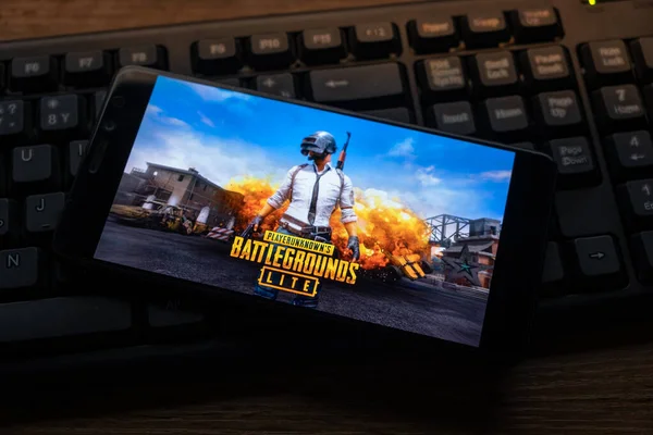 Kostanay, Kazajstán, 19 de octubre de 2019.Teléfono móvil en el fondo del teclado, con el logotipo del popular juego Playerunknown 's Battlegrounds . —  Fotos de Stock