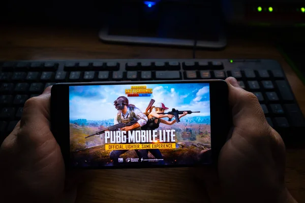 Kostanay, Kazajstán, 19 de octubre de 2019.Teléfono móvil en el fondo del teclado, con el logotipo del popular juego Playerunknown 's Battlegrounds . — Foto de Stock