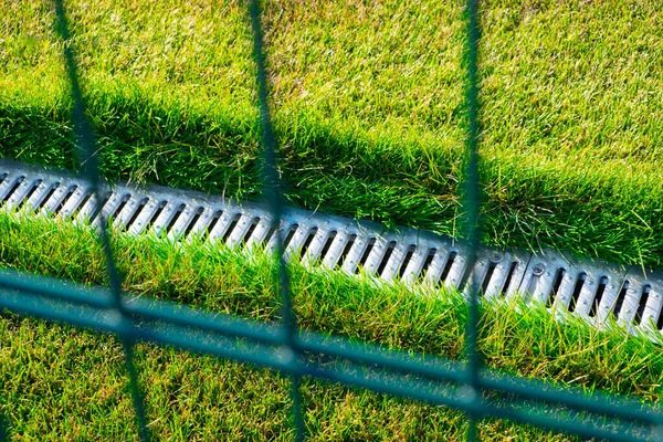 Sistema de drenagem no campo de futebol com um gramado verde brilhante . — Fotografia de Stock