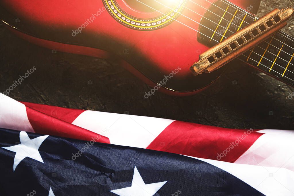 Star spangled banner, guitar and harmonica in the sunlight.Musical instrument and the flag of the United States