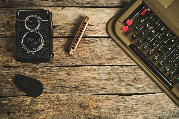 Old retro typewriter, camera and typewriter on a wooden background