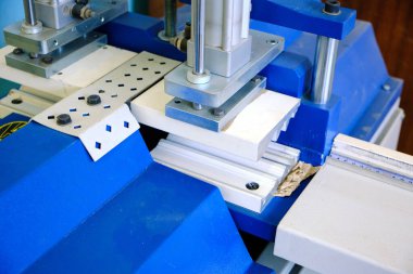 Plastik profilleri beyaz ve mavi renkte kesmek için endüstriyel makine