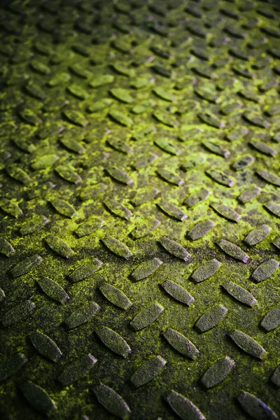 古く錆びた金属製の床は緑色で放射性です 凸型の粗い金属板の質感 — ストック写真