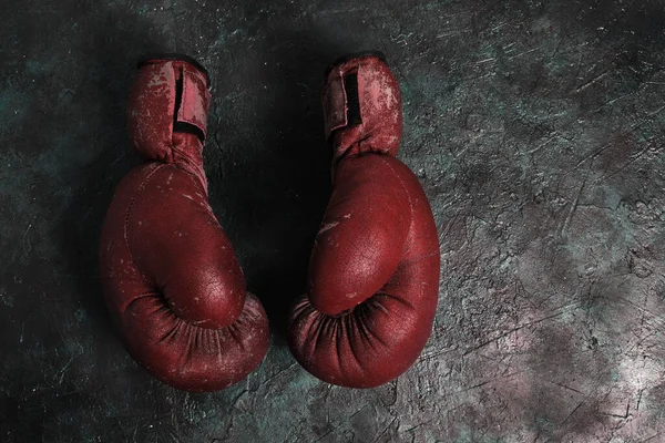 コンクリートの背景に古い赤いボクシングの手袋 — ストック写真