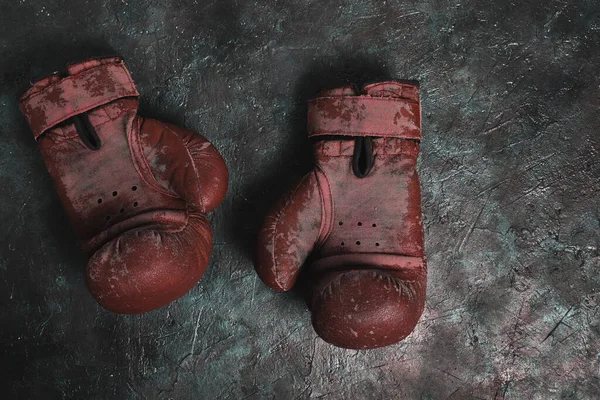 Old red Boxing gloves on a concrete background