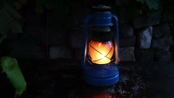 Brennende Petroleumlampe Gegen Eine Steinmauer Und Ein Wind Schwankender Rebzweig — Stockvideo
