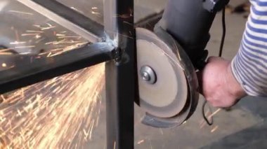 Kaynakçı kaynak makinesiyle dikişleri işliyor, kıvılcımlar uçuşuyor.