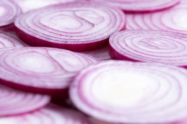 Beyaz arkaplanda dilimlenmiş kırmızı soğan halkaları