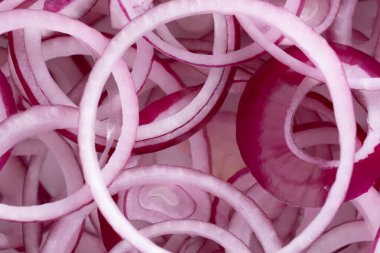 Arka plan olarak dilimlenmiş kırmızı soğan halkaları yakın plan