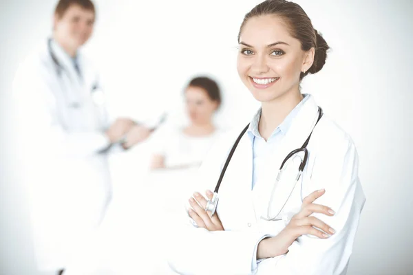 Glada leende kvinna-läkare på bakgrunden av sin patient i sängen. Medicinskt koncept — Stockfoto