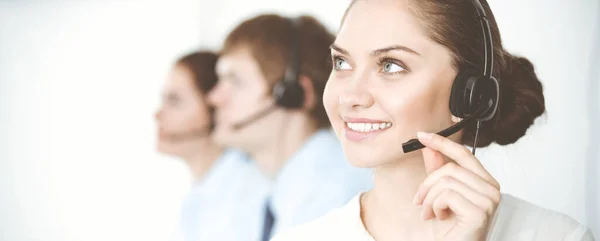 Call center. Diverse customer service operators in headsets at work in office. Business concept