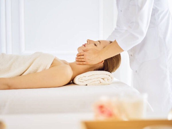 Beautiful woman enjoying facial massage with closed eyes