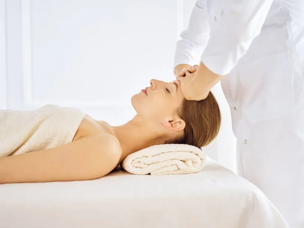 Belle femme bénéficiant d'un massage facial avec les yeux fermés — Photo