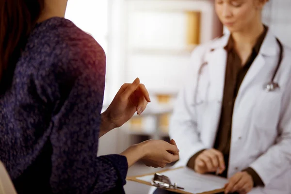 Doktor ve hasta güneşli klinikte otururken sağlık muayenesini tartışıyorlar. Hastanede mükemmel bir tıbbi hizmet. — Stok fotoğraf