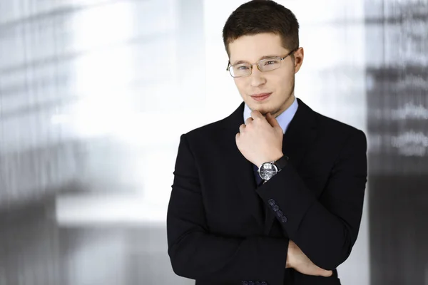 Jovem empresário vestindo terno, com óculos, enquanto estava no escritório. Conceito de sucesso empresarial hoje em dia — Fotografia de Stock