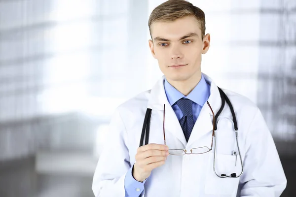 Dokter Man, met bril en stethoscoop, staat in zijn ziekenhuiskantoor. Perfecte medische dienst in de kliniek. Gelukkige toekomst in de geneeskunde en de gezondheidszorg — Stockfoto