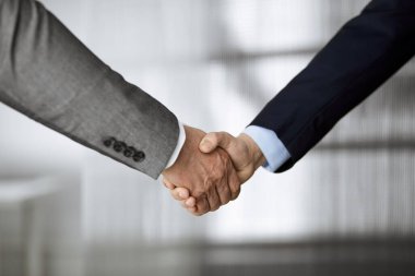 Ofisteki iş adamları ayakta ve el sıkışıyorlar, yakın plan. İş iletişimi kavramı. El sıkışma ve pazarlama