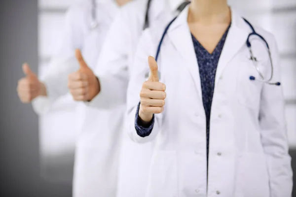 Médicos em pé como uma equipe com os polegares para cima na clínica e pronto para ajudar os pacientes. Conceito de assistência médica, seguro e medicina — Fotografia de Stock