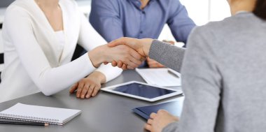 Bir grup iş adamı modern ofiste soruları tartıştıktan sonra el sıkışıyor. El sıkışın, yakın plan. İş konseptinde takım çalışması, ortaklık ve anlaşma