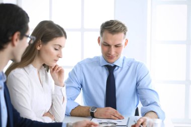 Bir grup iş adamı modern ofiste soruları tartışıyor. Pazarlık yapan ya da beyin fırtınası yapan yöneticiler. Takım çalışması, ortaklık ve iş konsepti