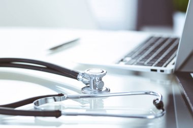 Stetoskop, cam masada dizüstü bilgisayarla duran reçeteli tıbbi form. İlaç ya da eczane konsepti. Doktor çalışma masasında tıbbi aletler