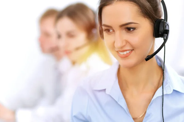 Bel het centrum. Focus op mooie zakelijke vrouw met behulp van headset in zonnig kantoor — Stockfoto