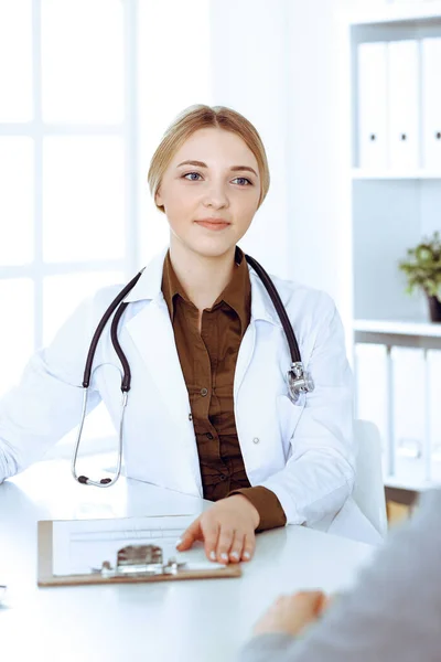 Junge Ärztin und Patientin bei der ärztlichen Untersuchung im Krankenhaus. Die khakifarbene Bluse des Therapeuten sieht gut aus. Medizin, Gesundheitswesen und Arztterminkonzept — Stockfoto