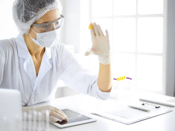 Cientista profissional em óculos de proteção pesquisando tubo com reagentes em laboratório. Conceitos de medicina e pesquisa — Fotografia de Stock