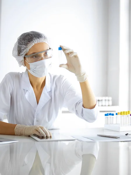 Cientista profissional em óculos de proteção pesquisando tubo com reagentes em laboratório. Conceitos de medicina e pesquisa — Fotografia de Stock