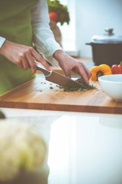 Mutfakta pişen bilinmeyen insan elleri. Kadın sebze salatasıyla meşgul. Sağlıklı yemek ve vejetaryen gıda konsepti.