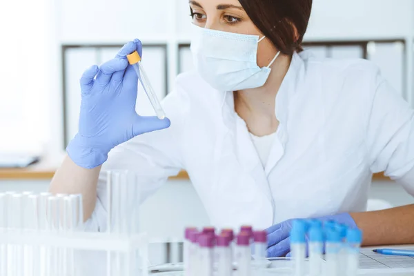 Close-up de cientista profissional feminino em óculos de proteção fazendo experiência com reagentes em laboratório. Medicina e conceito de pesquisa — Fotografia de Stock