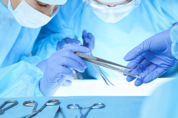 Close-up of medical team performing operation. Group of surgeons at work are busy of patient. Medicine, veterinary or healthcare and emergency in hospital