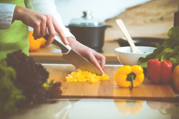 Manos humanas desconocidas cocinando en la cocina. Mujer cortando pimiento amarillo. Comida saludable y concepto de comida vegetariana —  Fotos de Stock