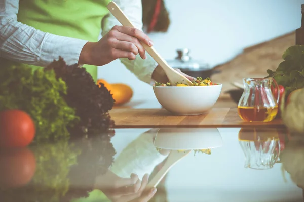 Onbekende mensenhanden die koken in de keuken. Vrouw is bezig met groentesalade. Gezonde maaltijd en vegetarisch voedselconcept — Stockfoto