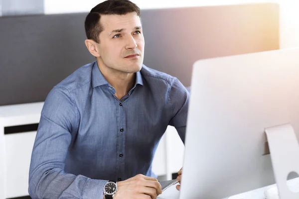 Geschäftsmann arbeitet mit Computer in modernem, sonnigen Büro. Kopfschuss eines männlichen Unternehmers oder Firmendirektors am Arbeitsplatz. Geschäftskonzept — Stockfoto