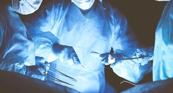 Gruppe von Chirurgen mit Schutzmasken bei der Operation. Medizinkonzept — Stockfoto