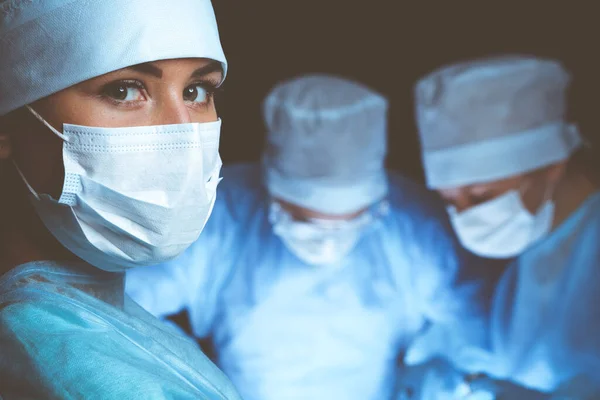 Grupo de cirujanos con máscaras de seguridad realizando la operación. Concepto de medicina —  Fotos de Stock