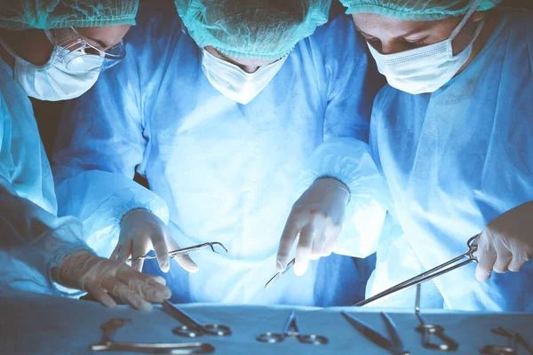 Groupe de chirurgiens portant des masques de sécurité effectuant l'opération. Gros plan sur les outils chirurgicaux. Concept de médecine — Photo