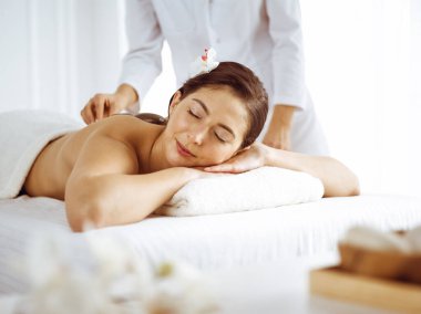 Güzel esmer kadın gözleri kapalı sırt masajından hoşlanıyor. Spa ve tıp konsepti